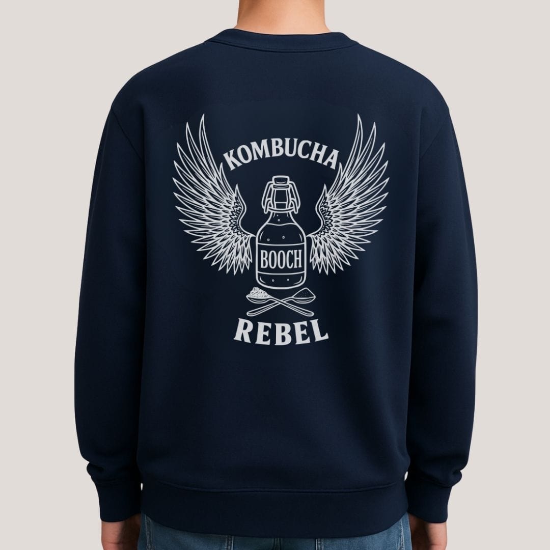 Mock up images of navy Kombucha Rebel back print sweatshirt for fans of fermentation, featuring a bottle of booch with dramatic wings and crossed spoons - one with tea leaves and one with sugar. Design inspired by vintage Harley Davidson jackets.
