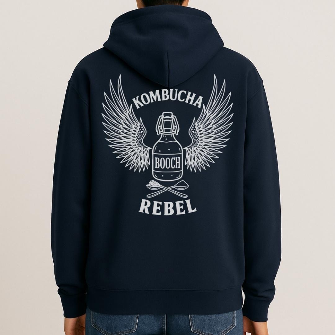 Mock-up of navy Kombucha Rebel back print hoodie for fans of fermentation, featuring a bottle of booch with dramatic wings and crossed spoons - one with tea leaves and one with sugar. Design inspired by vintage Harley Davidson jackets.