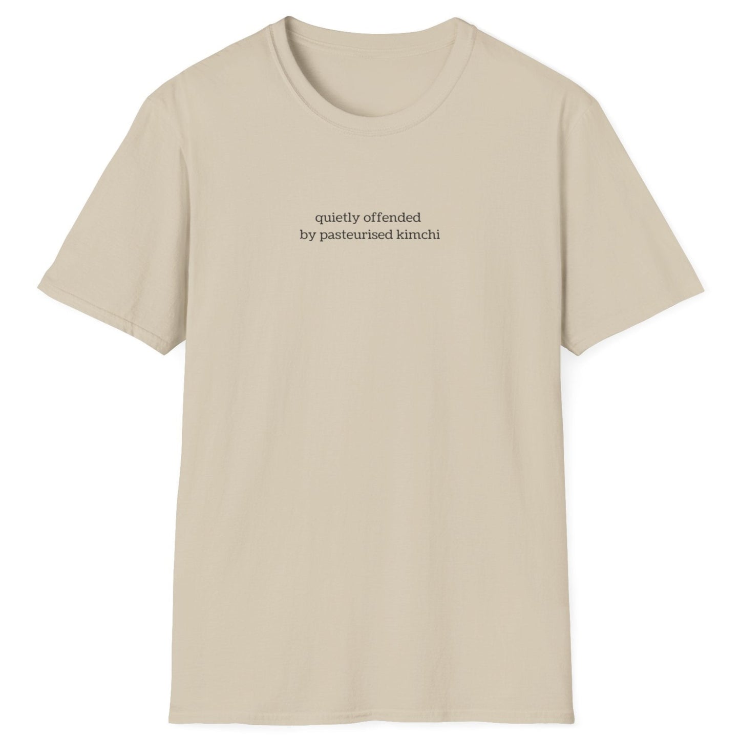 Minimalist neutral t-shirt with lowercase black text reading “quietly offended by pasteurised kimchi” — subtle tee for wild fermenters and cultured food fans.